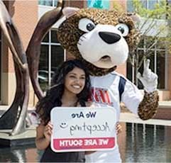 南Paw and a USA Student hold a sign that states: 我们是 Accepting